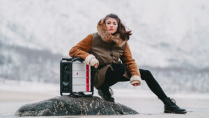 A woman sitting on a rock with an Instagrid suitcase.