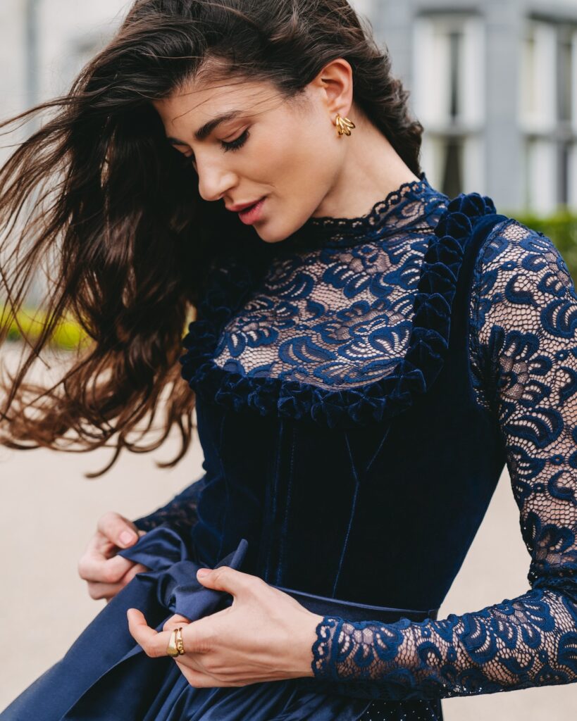 Eine Frau in einem blauen Kleid posiert für ein Foto.
