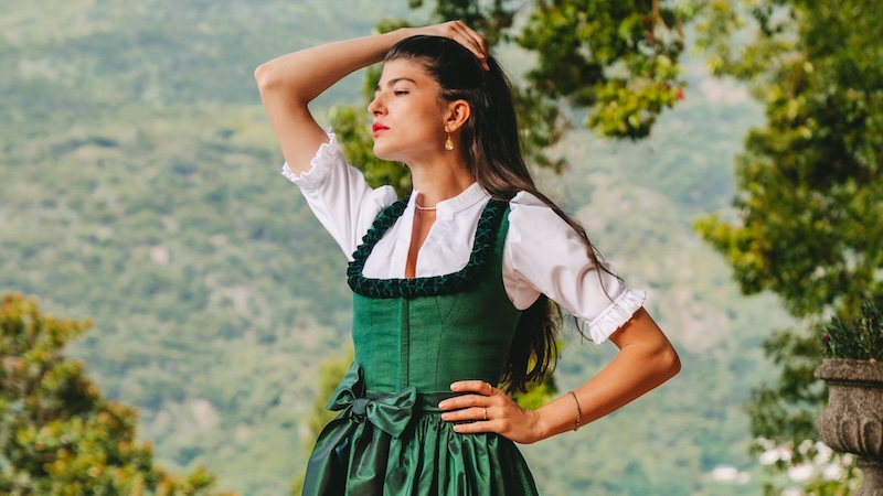 A woman in a green dress poses for a photo.