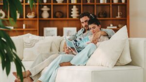 A couple reading a book on the couch.